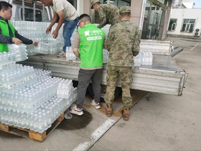 美团驰援3万件救灾物资 已陆续送达北京强降雨受灾地区 ▲美团小象超市工作人员与怀柔北房镇救援人员搬运救灾物资(王磊 摄)